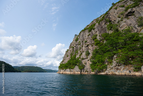 Steep cliffs off a mountain into a deep fjord.