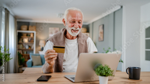 One senior man use laptop computer hold credit car shopping online