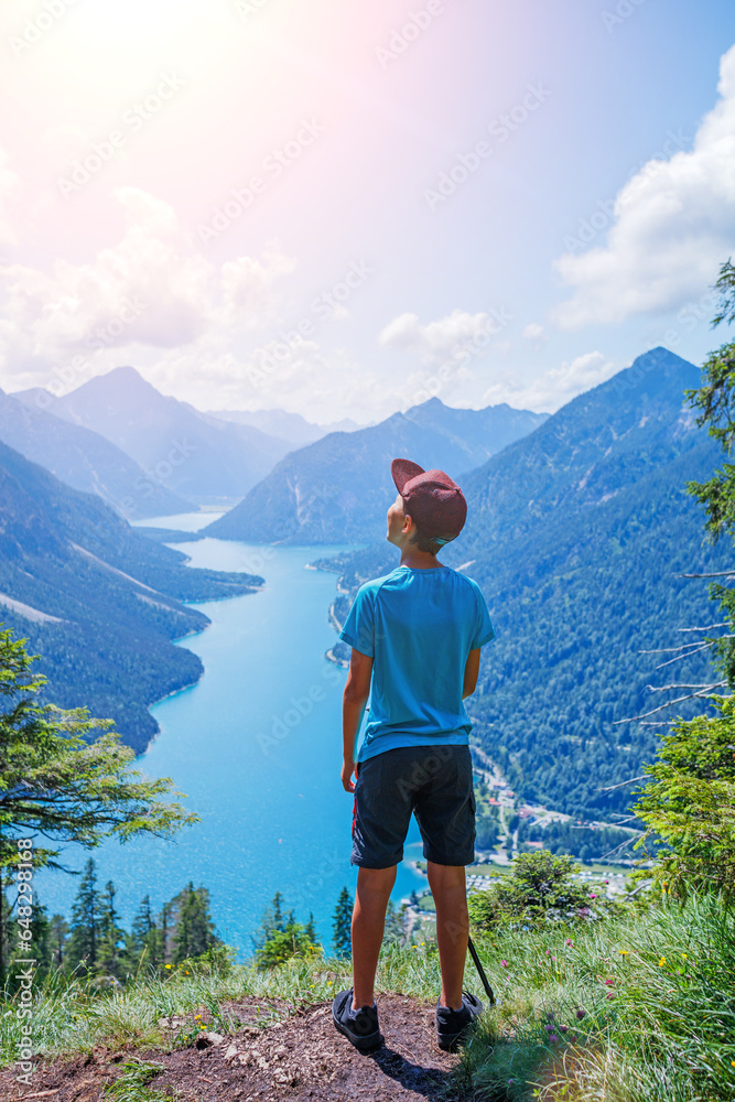 Naklejka premium Cute boy with hiking equipment in the mountains