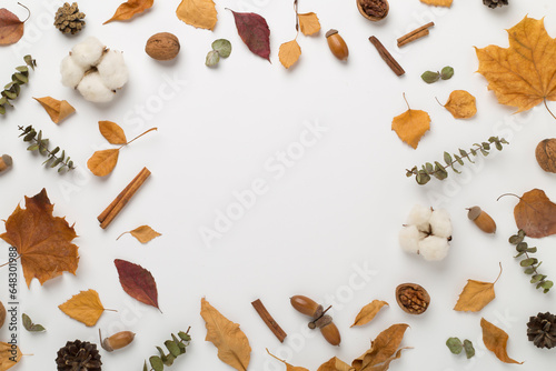Autumn leaves with decor on color background, top view
