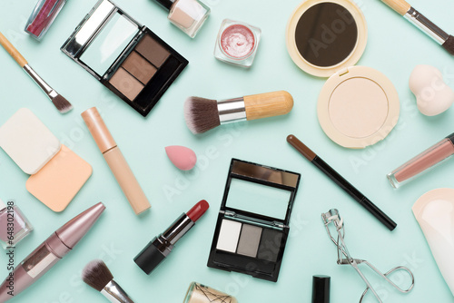 Flat lay with makeup products and tools on color background
