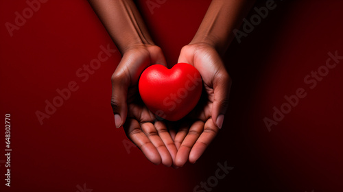 World AIDS day concept. Handsholding red heart.  photo