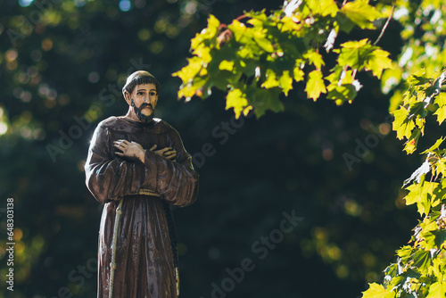 sculpture, figure of a monk among the trees  photo