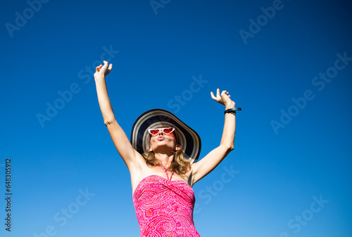 happy woman in pink swimsuit against blue sky holiday concept