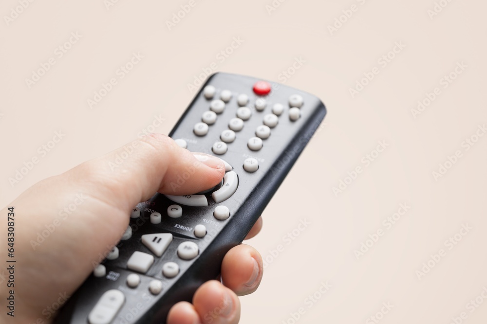 Hand holding classic plastic tv remote Hand holding classic plastic tv remote