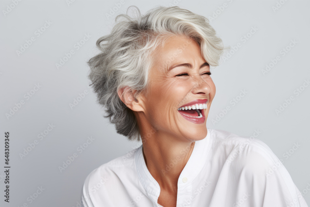 A closeup photo portrait of a beautiful elderly senior model woman with grey hair laughing and smiling with clean teeth. used for a dental ad. isolated on white background. A closeup photo portrait of a beautiful elderly senior model woman with grey hair laughing and smiling with clean teeth. used for a dental ad. isolated on white background.