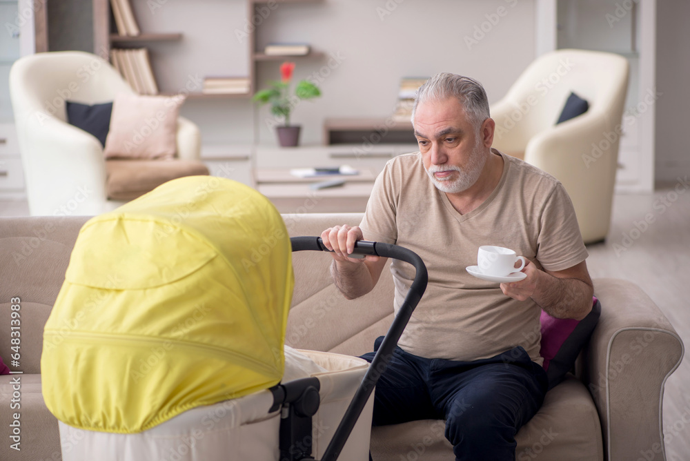 Obraz premium Old man looking after newborn at home