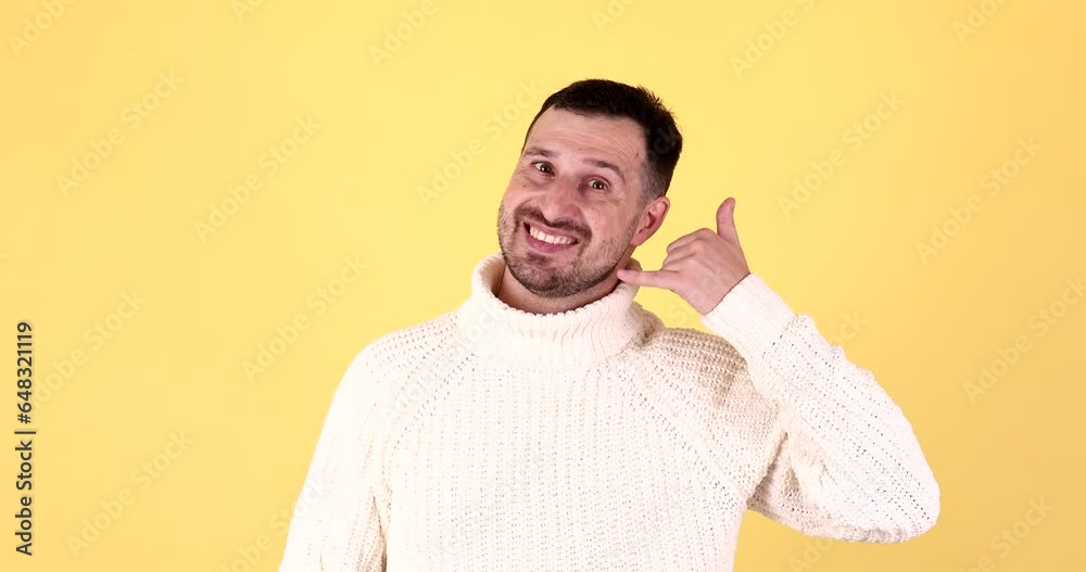 Cheerful caucasian man call me gesture on yellow background. Cheerful caucasian man call me gesture on yellow background.