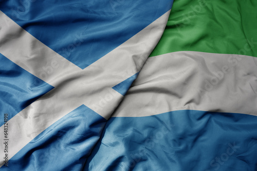 big waving national colorful flag of scotland and national flag of sierra leone .