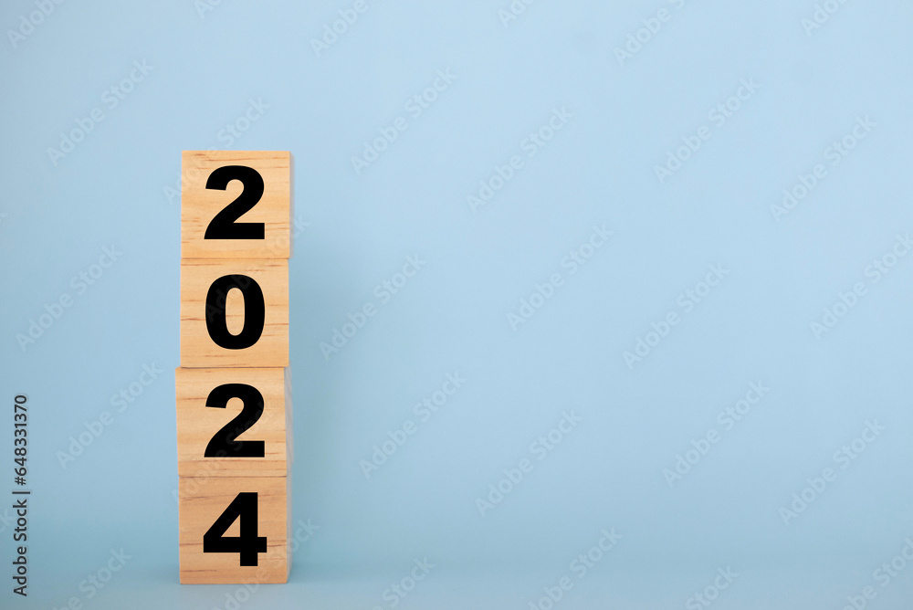 Wooden cubes with text 2024 on blue background with copy space. Wooden cubes with text 2024 on blue background with copy space.