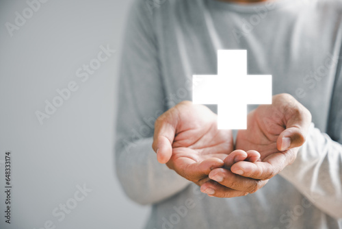Obraz na plátně Hand holds plus icon for healthcare, symbolizing benefits
