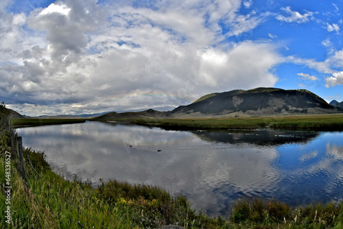 Photography The slow moving Flat Creek provides mirror like flatness reflecting clouds, Jack
