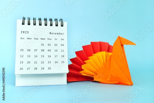 Selective focus of November 2023 desk calendar with turkey bird paper decoration. Thanksgiving day season. photo