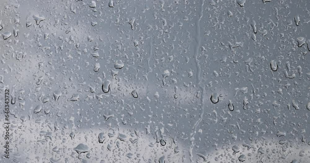 glass with water drops during rain, glass covered with rain water drops in a building window glass with water drops during rain, glass covered with rain water drops in a building window
