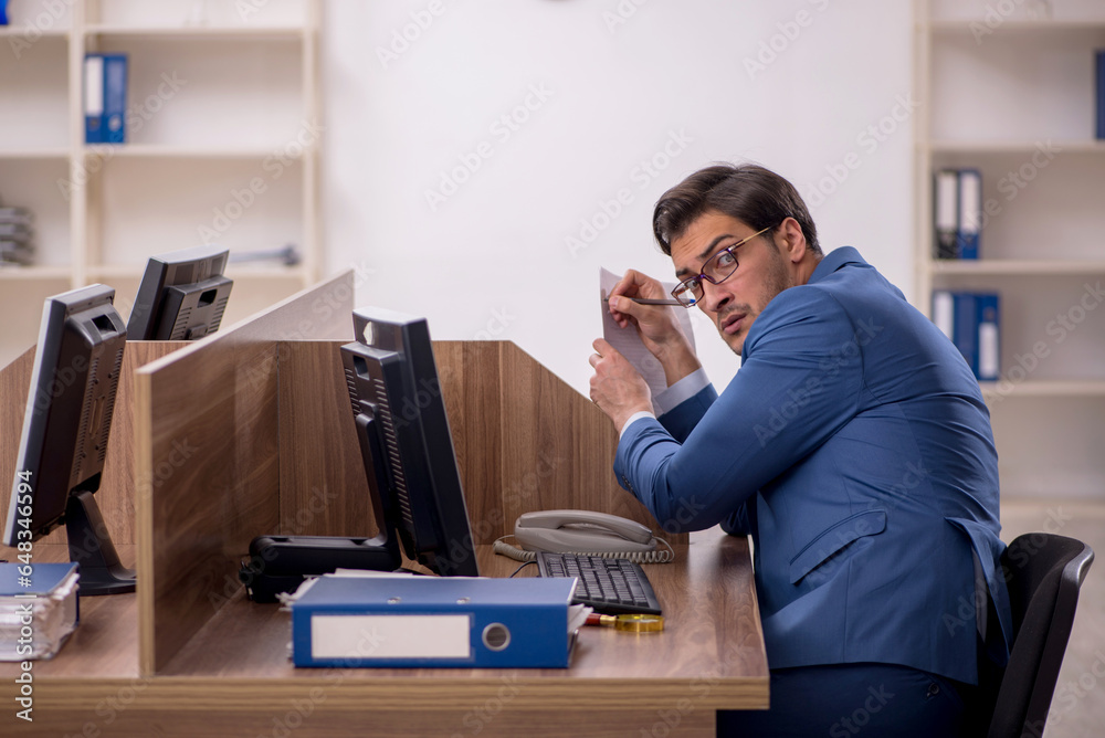 Young male employee working in the office Young male employee working in the office