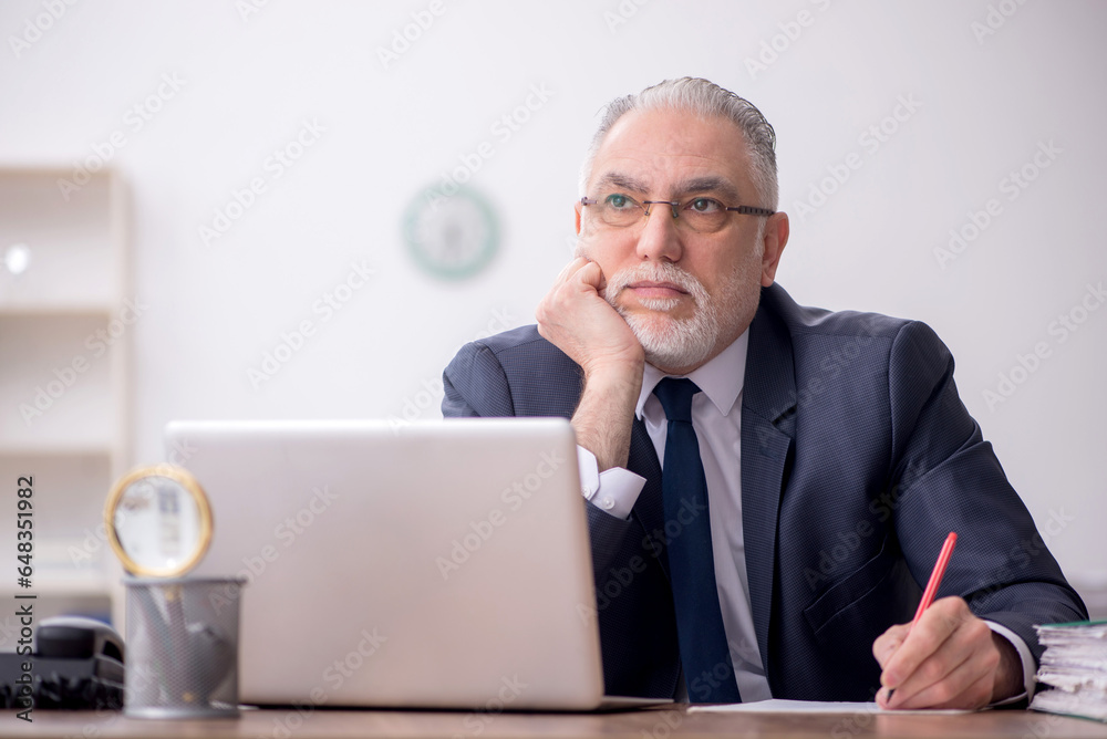 Old male employee working in the office Old male employee working in the office