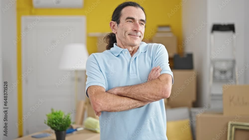 Middle age man smiling confident standing with arms crossed gesture at new home Middle age man smiling confident standing with arms crossed gesture at new home
