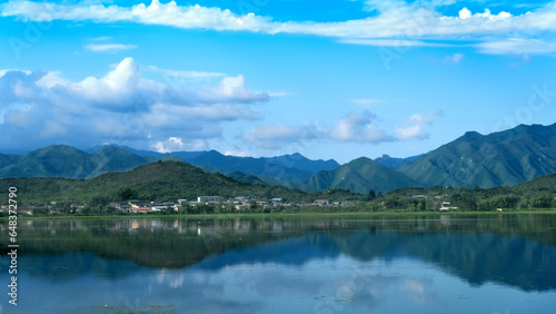 white clouds,blue sky,blue lake,green plants and green mountains. 