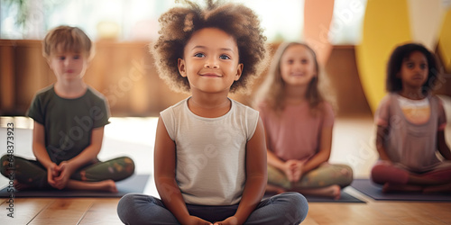 Group diverse little girls sitting in lotus position meditating during session at yoga studio. Girls practicing exercises visualizing calming the brain increasing awareness and attentiveness