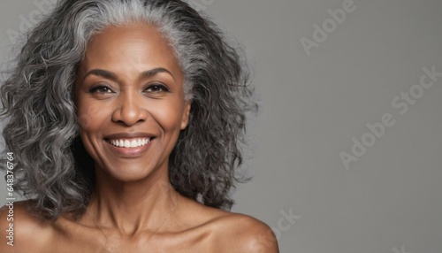 Beauty and cosmetics skincare advertising concept featuring a beautiful black woman with smooth healthy face skin and long gray hair