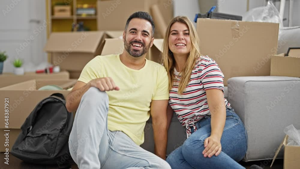 Man and woman couple having video call sitting on floor at new home Man and woman couple having video call sitting on floor at new home