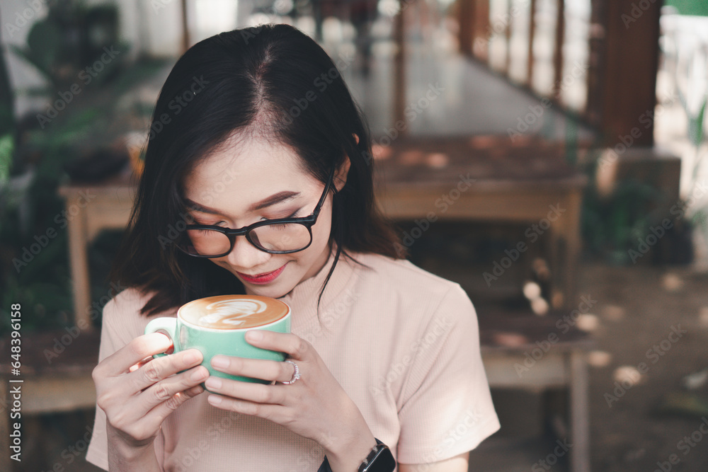 Young asian woman drinking coffee latte at a cafe
Young asian woman drinking coffee latte at a cafe
