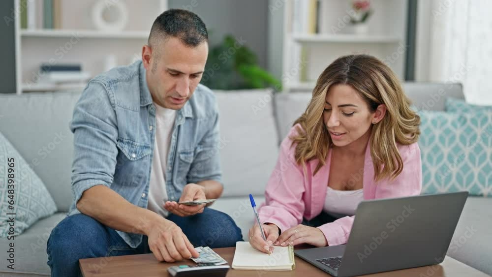 Man and woman couple using laptop and taking notes counting peruvian soles at home Man and woman couple using laptop and taking notes counting peruvian soles at home