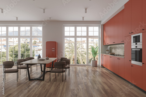 Orange hotel kitchen interior with dining and cooking space, panoramic window