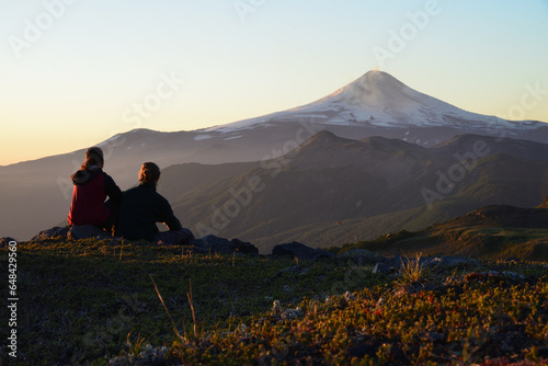 Paar sitzt vor Vulcan Villarice und genießt den Sonnenuntergang