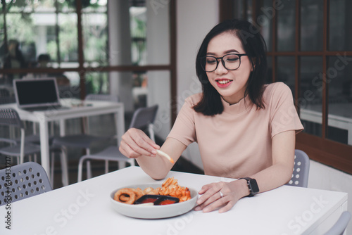 Beautiful asian woman eating food at a cafe
