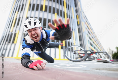 Cyclist screaming falls off bike onto asphalt. Fatal injury related to cycling concept
