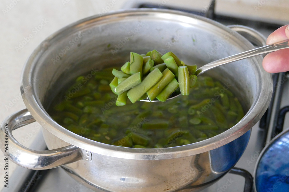 Chopped green beans are cooking in a pot, green beans are boiled in a pot, bean dish,