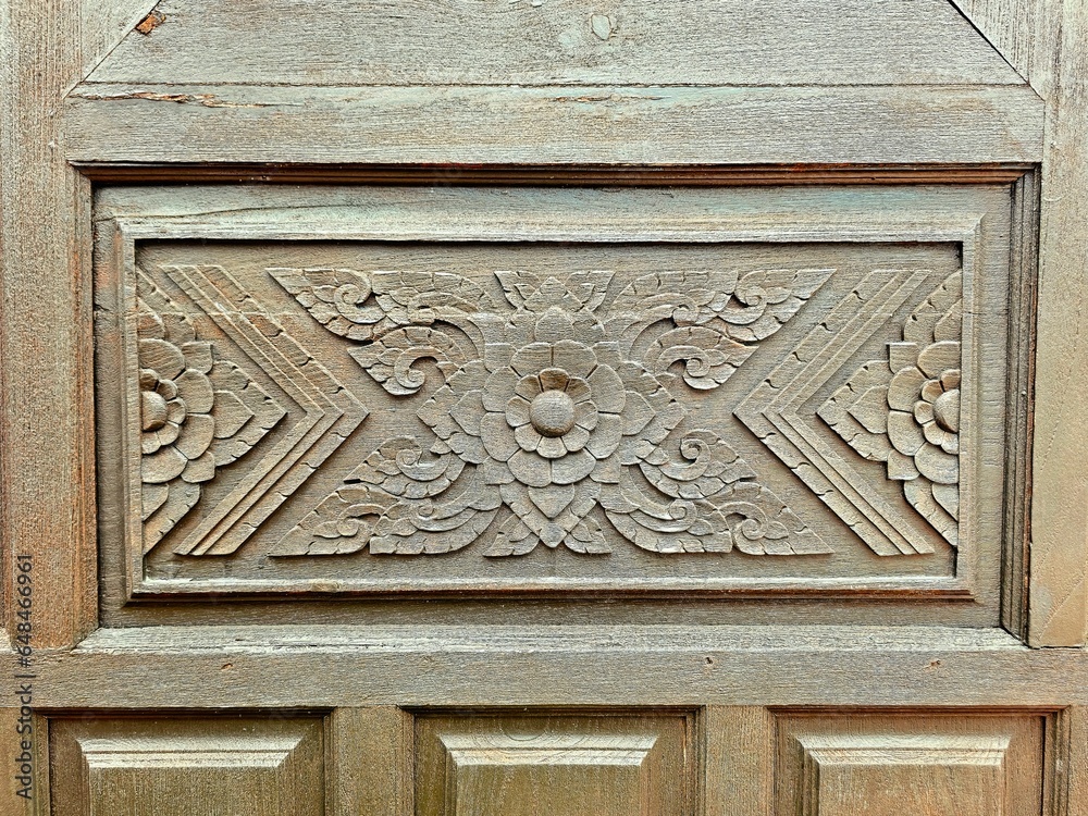 Wooden door with carved ornament close-up. Selective focus.