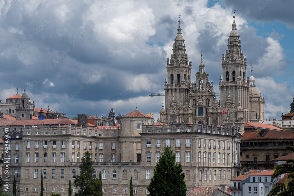 Distant view of Santiago de Compostela Cathedral and surrounding buildings on a cloudy day. Facade of the Obradoiro. Monumental site.