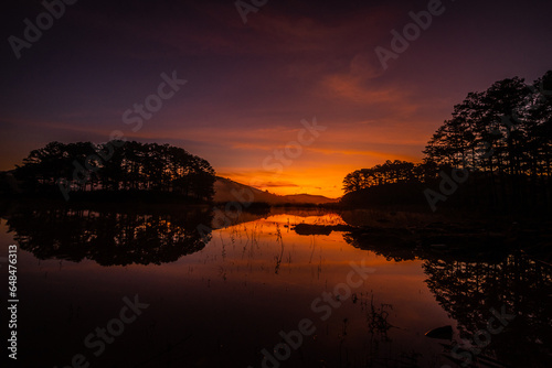 Moments before dawn, the bright red clouds in the stream were golden and the clouds reflected on the stream