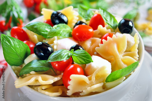 Bow tie pasta salad with mozzarella, black olives and cherry tomatoes
