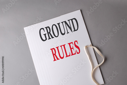 GROUND RULES text on white folder on grey background