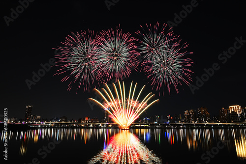 Colorful fireworks of various colors over night sky with    reflection in water © lcc54613