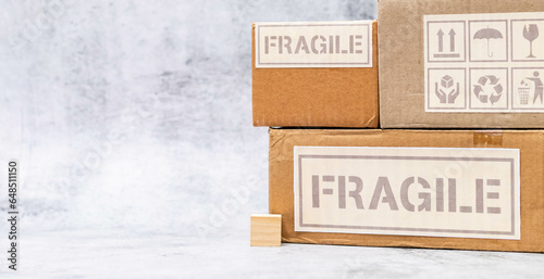 Wide shot of fragile boxes with wooden cube placed on marble surface.