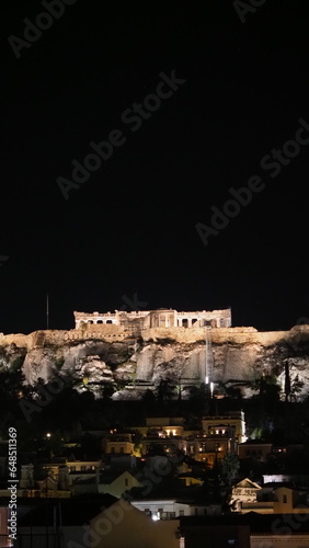 Cityscape of Athens with illuminated Acropolis hill, Pathenon and sea at night, Greece photo