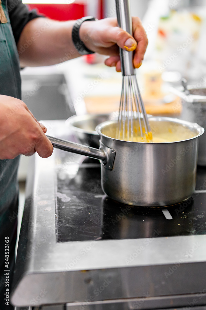 Chef hands cooking cheese sauce in the restaurant kitchen Chef hands cooking cheese sauce in the restaurant kitchen