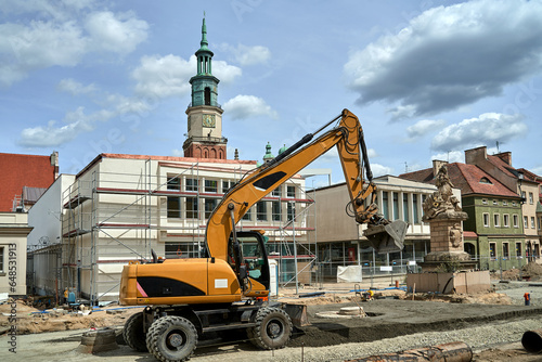 Excavator during renovation of the Old Market Square with the historic town hall in Poznan