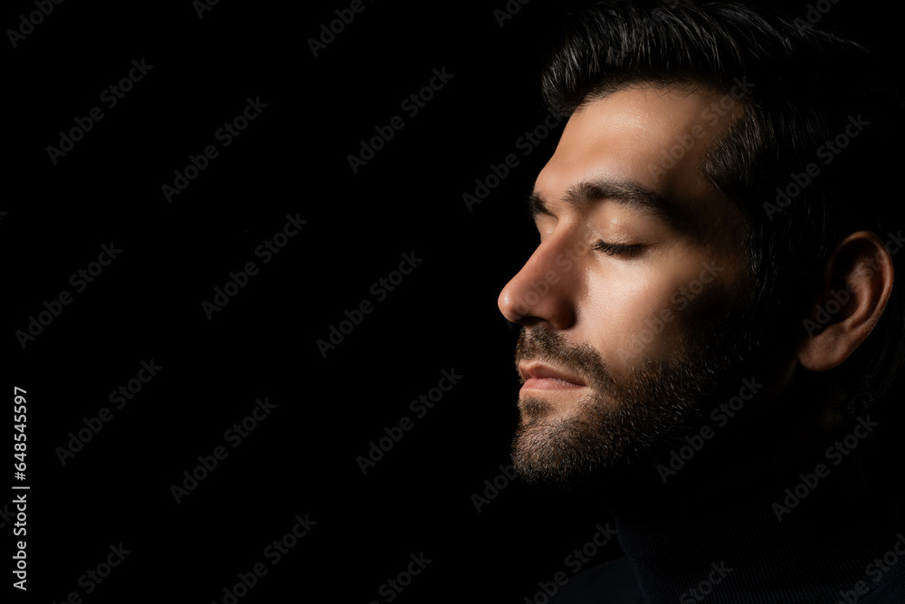 Close up face Caucasian handsome man isolated on black background Handsome man close eyes in studio on dark background Attractive Bearded guy thinking something in the dark room