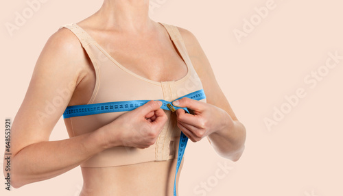 Woman taking measurements after breast augmentation. Copy space