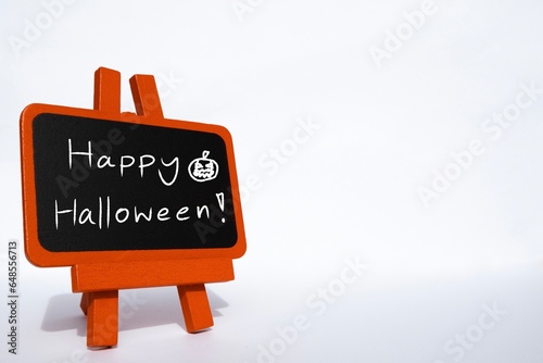 Happy Halloween message hand written on orange sign for card and web decoration. Halloween illustration with copy space.