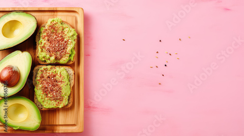 Top view of a wooden board with delicious avocado toast with multigrain bread isolated on a flat pink background with copy space. 
