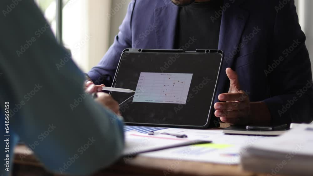 Businessmen colleagues discussing analyzing financial growth charts on tablet and planning business and investment strategies. Businessmen colleagues discussing analyzing financial growth charts on tablet and planning business and investment strategies.