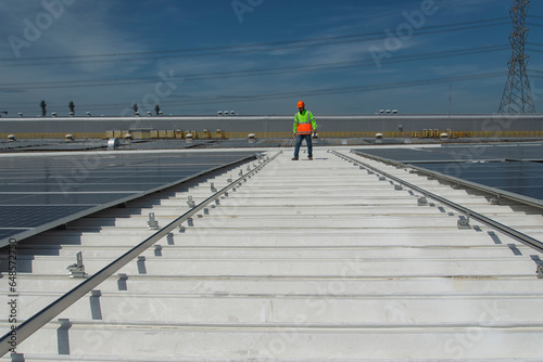  engineer checking solar energy panel installation on roof top.