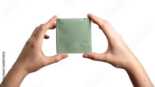 Tea bag, sachet, pouch pack mock up. Green teabag mockup in hands, isolated on white photo