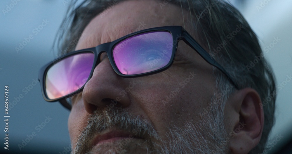 Mature doctor in glasses stands outdoors near hospital in the evening. Tired medic drinks coffee, looks at the sky. Work in clinic or modern medical center. Healthcare concept. Close up. Portrait. Mature doctor in glasses stands outdoors near hospital in the evening. Tired medic drinks coffee, looks at the sky. Work in clinic or modern medical center. Healthcare concept. Close up. Portrait.
